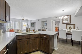 A kitchen with brown cabinets and a white counter.